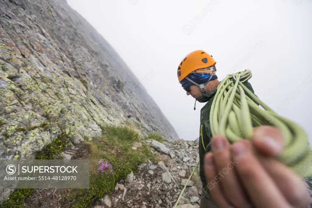 Side view of climber coiling rope.