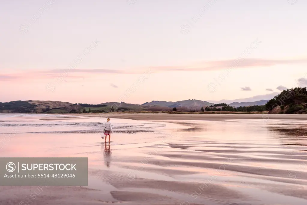 Young female on remote beach in New Zealand