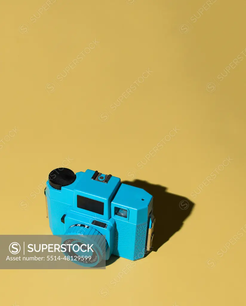 Blue Camera on Yellow Background