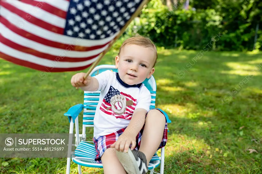 Toddler boy holding American flag wearing Patriotic shirt