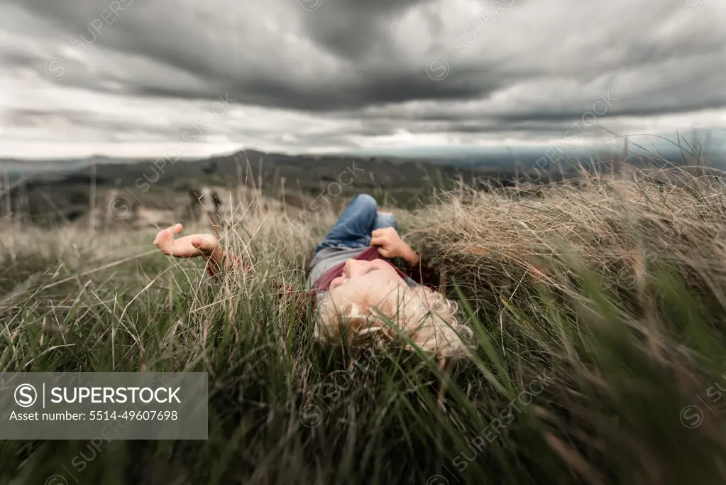 Young boy lying in tall grass