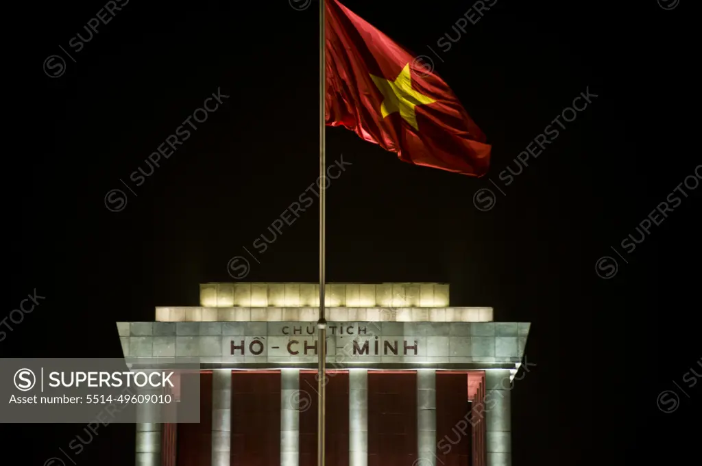 Ho Chi Minh mausoleum at night and Vietnam flag fluttering in the wind