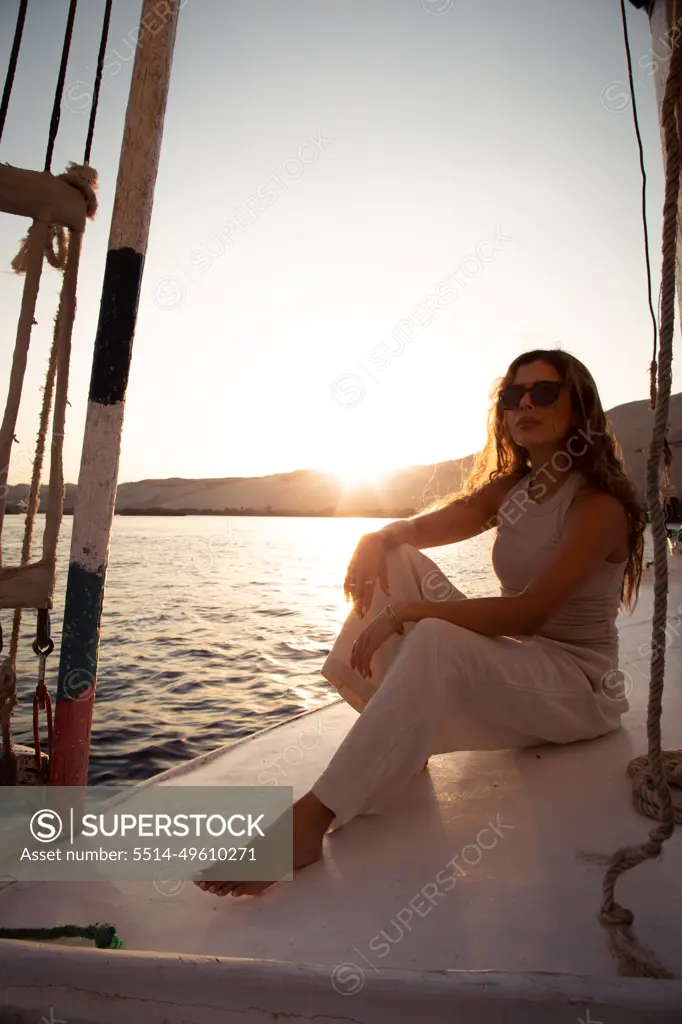 Young woman on felucca sailing the nile river at sunset, Aswan