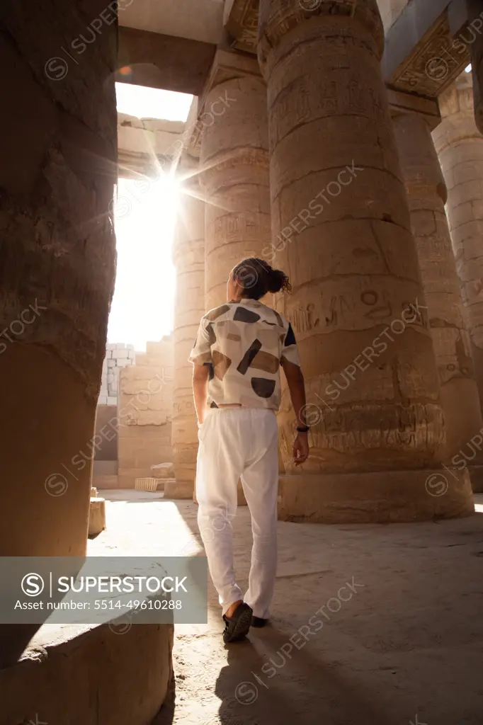 Man with hairbun, walking around the Hypostyle hall, Karnak Temple