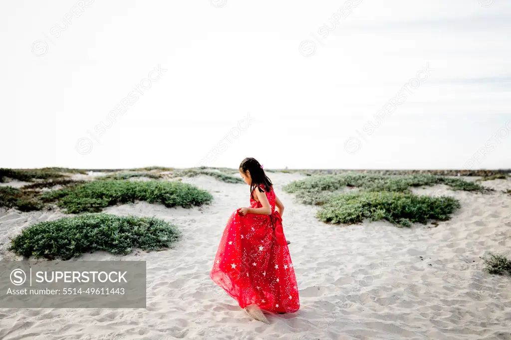 Six Year Old Asian Girl in Red Dress Walking on Beach