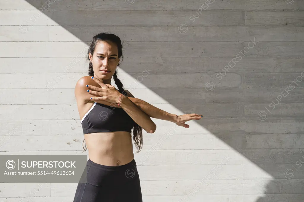 Upper body of female athlete stretching arms