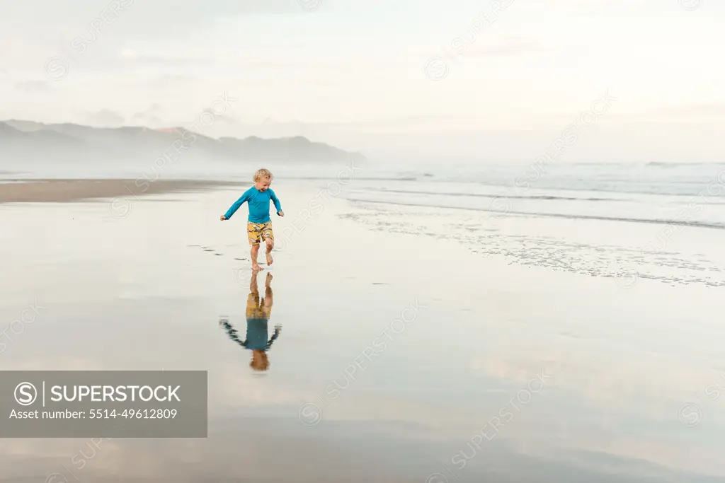 Child running on a beach in New Zealand