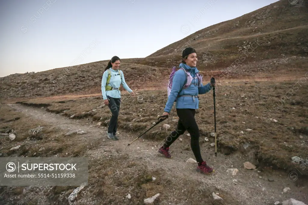 Two young women trail runners enjoy single track trail in the Rockies