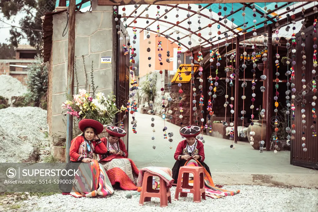 local woman in colourful traditional clothes weave on street by market