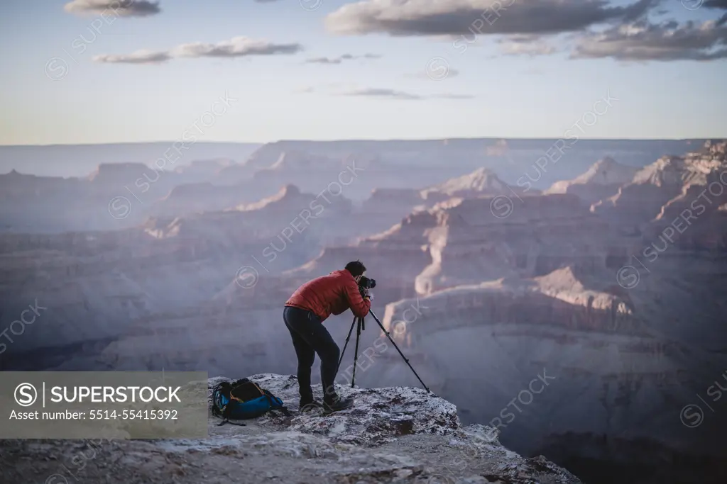 Male photographer with tripod at edge of Grand Canyon, Arizona