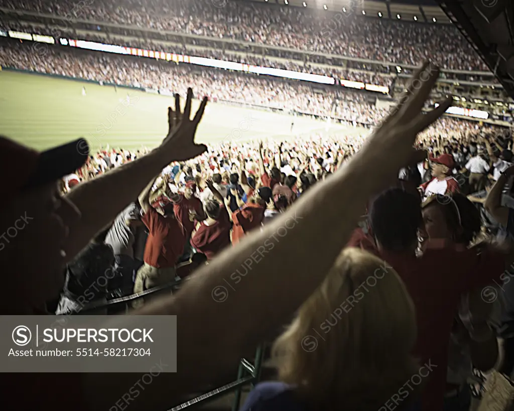 Baseball fans with outstretched arms, Angel Stadium of Anaheim, California.