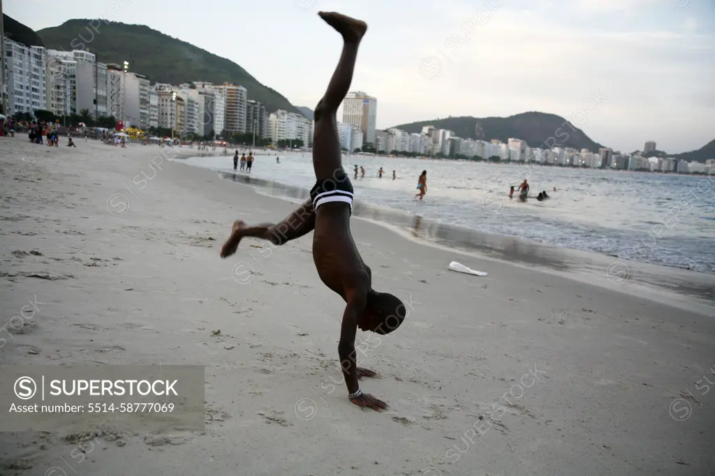 Kid doing acrobatics on Copacabana beach, Rio de Janeiro, Brazil.