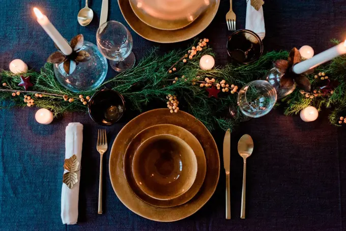 sky view of a modern dinner table setting with candles and greenery