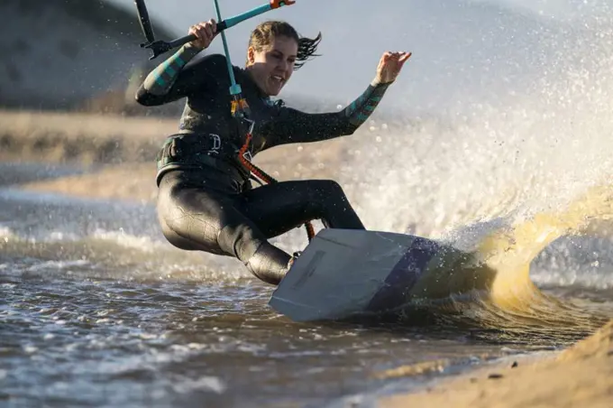 Action shot of an excited female athlete kiteboarding in Mexico