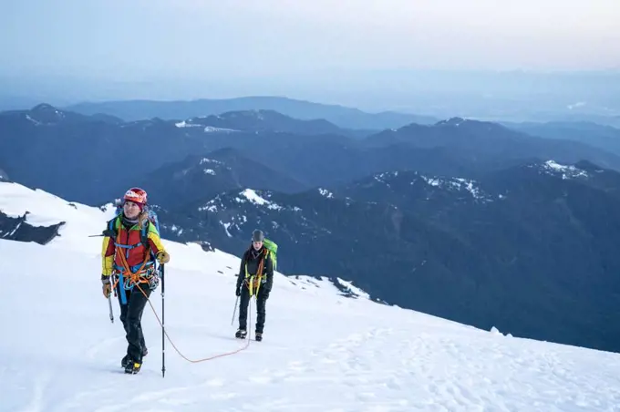 A female mountaineer looks up determinedly at the summit of Mt. Baker