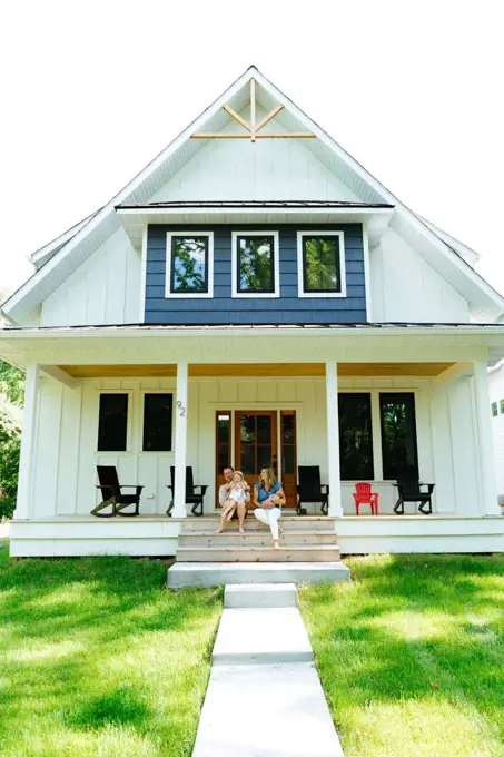 A family sitting together on a porch on a sunny summer day