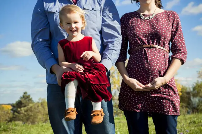 Young pregnant couple holding daughter in Detroit MI