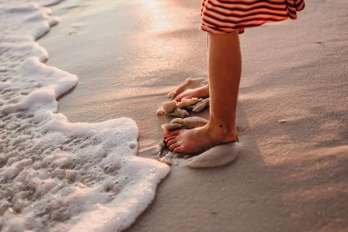 Burying her toes in the sand on the beach at Pensacola, Florida