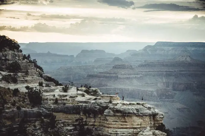 people over cliffs rocks in grand Canyon