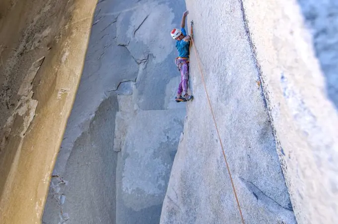 Rock climber looking down while climbing on big wall in Yosemite