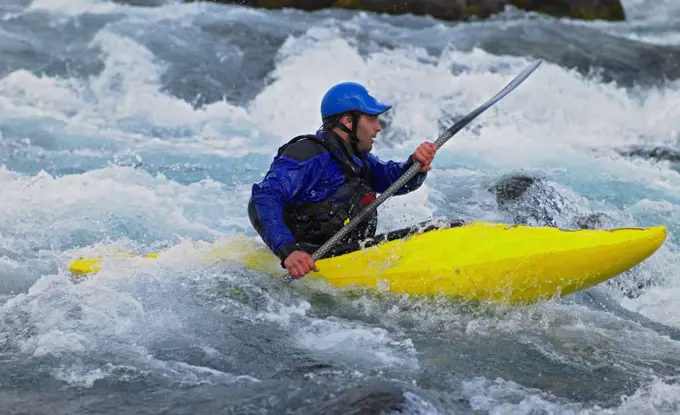 Man going on his white water kayak  rapids in an Icelandic river