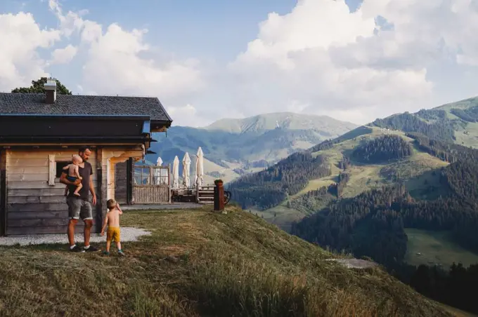 Father and children walking in mountains with stunning views in summer