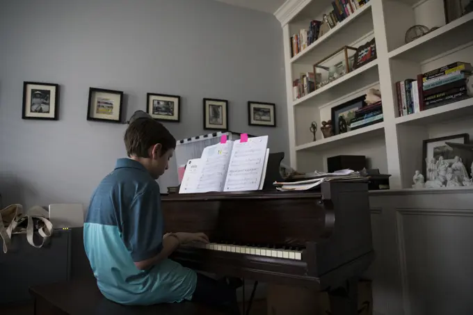 Low Side View of Teen Boy Playing Piano at Home from Marked Pages