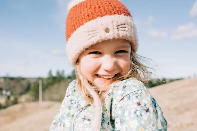 portrait of a young girl smiling with her hair blowing in the wind