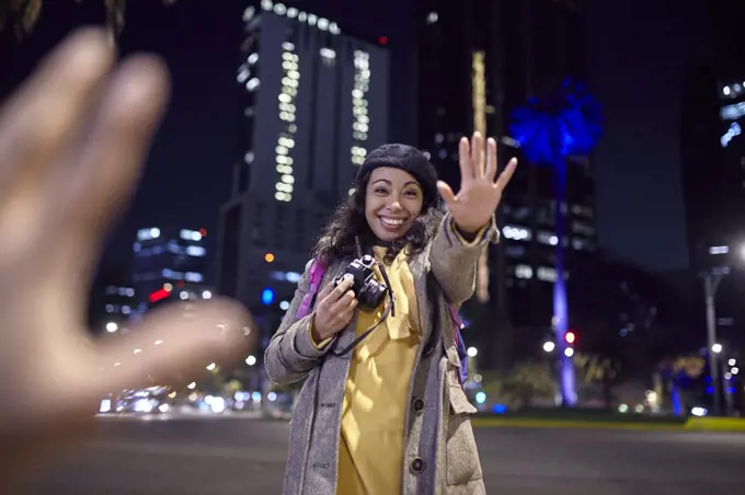 woman saying hello in the streets at night