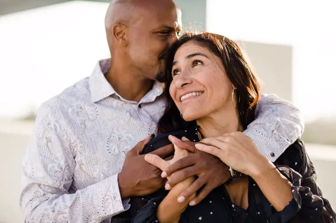 Multiracial Late Forties Couple Embracing at Sunset in San Diego