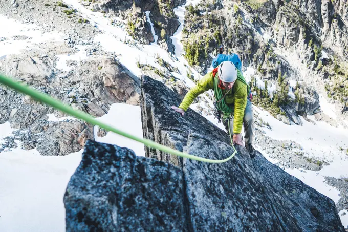 Rock climbing man climbing on mountain in Washington with rope