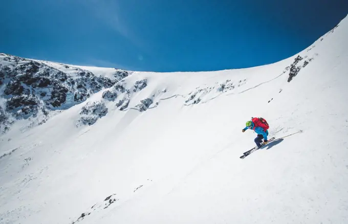 Man skiing down steep terrain in Tuckerman Ravine, New Hampshire