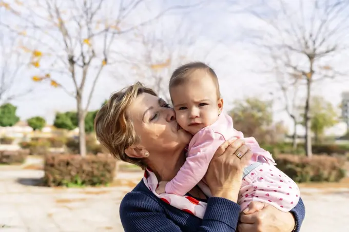 grandmother hugging her granddaughter in the park