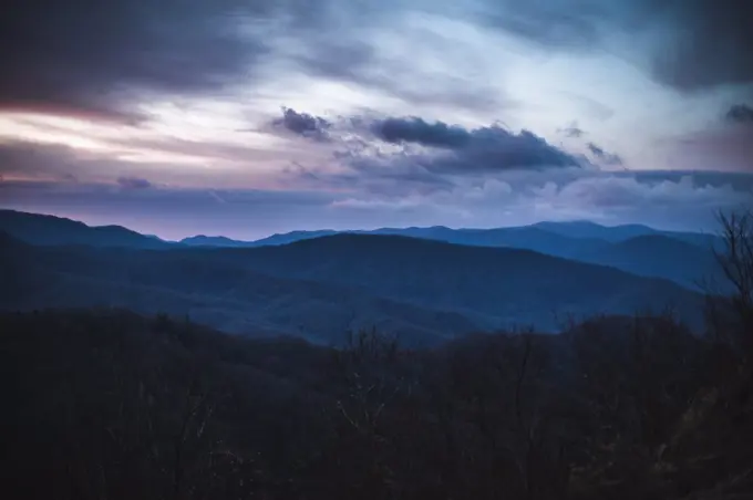 dramatic pink and purple clouds over smokey mountains at sunrise