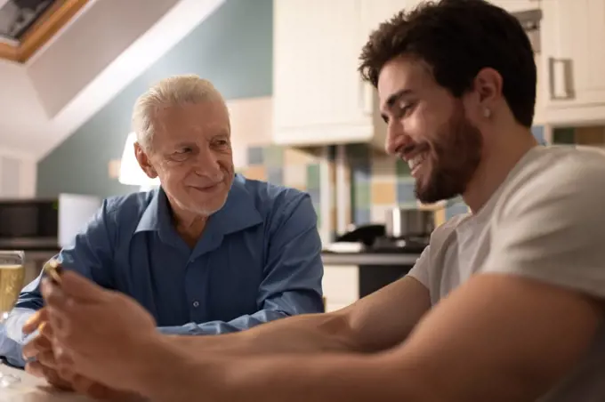 Loving senior father communicating with son with smartphone