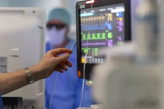 a doctor adjusts a dropper during surgery in the operating room