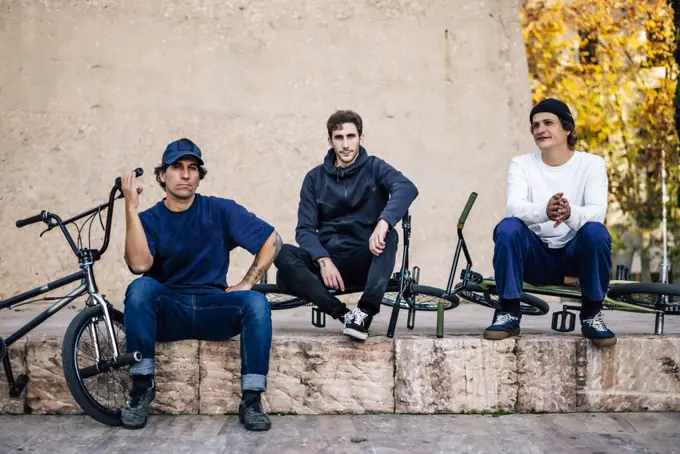 Three men posing with their bmx bikes in the city of Madrid Spain