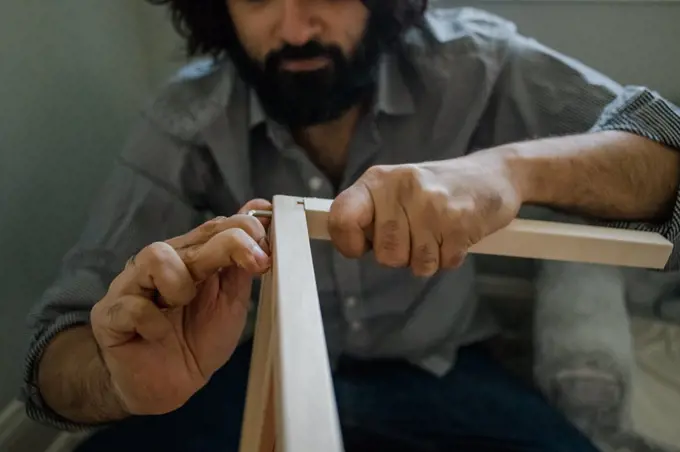 Dad building dollhouse with tools close up of hands