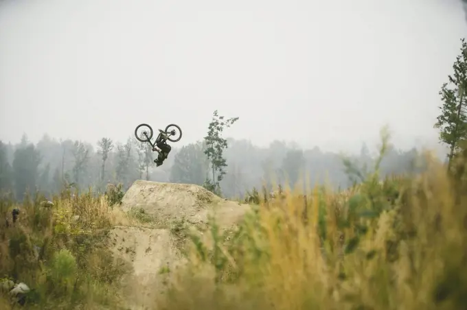 Mountain biker flipping a jump in Bellingham Washington