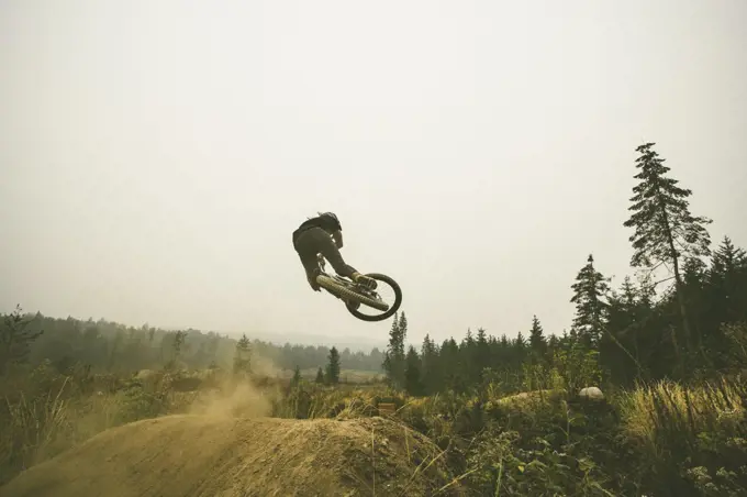 Mountain biker jumps dry dusty jumps in Bellingham Washington