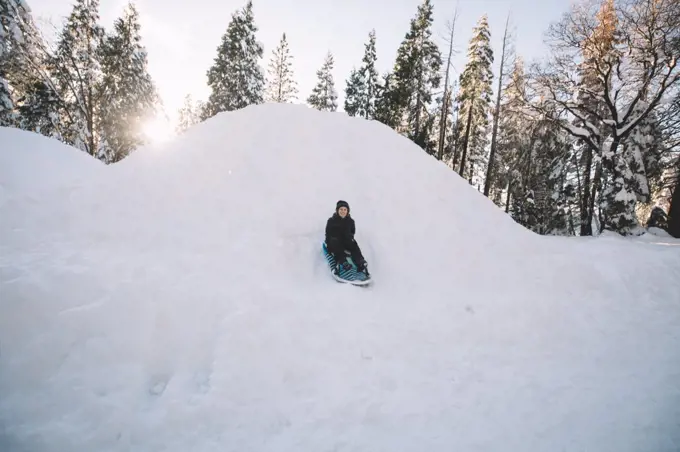 Young Boy Sledding Quickly Down a Hill.