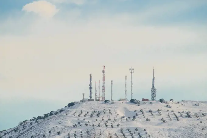 Group of telecommunications antennas on snowy mountain