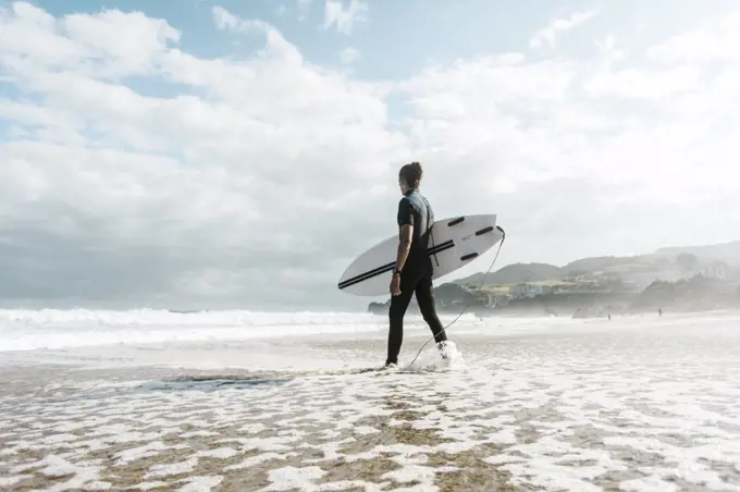 Surfer entering the water in the Basque country, Spain, Bilbao