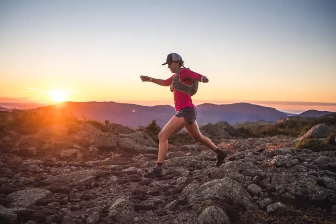 Woman running in the White Mountains at sunrise in summer