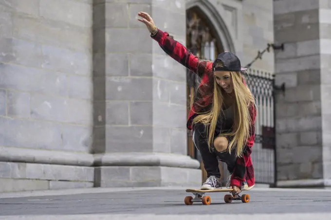 Female skateboarder balancing herself on skateboard rolling arou