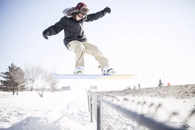 Young snowboarder performing a stunt in mid air