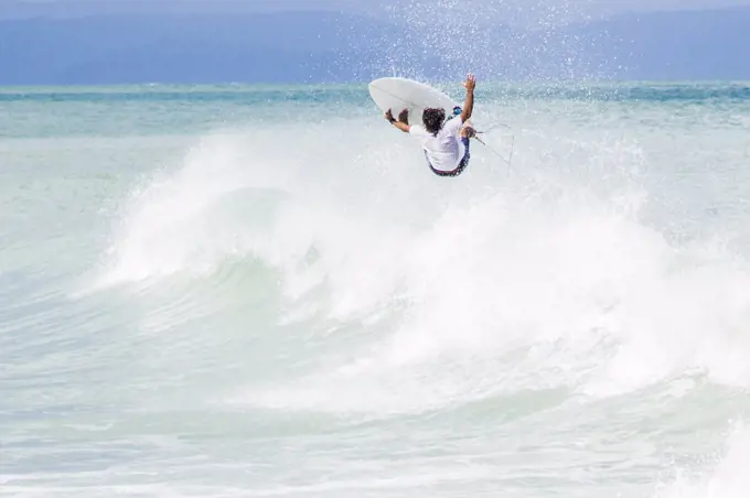 Surfer jumping on wave in mid air