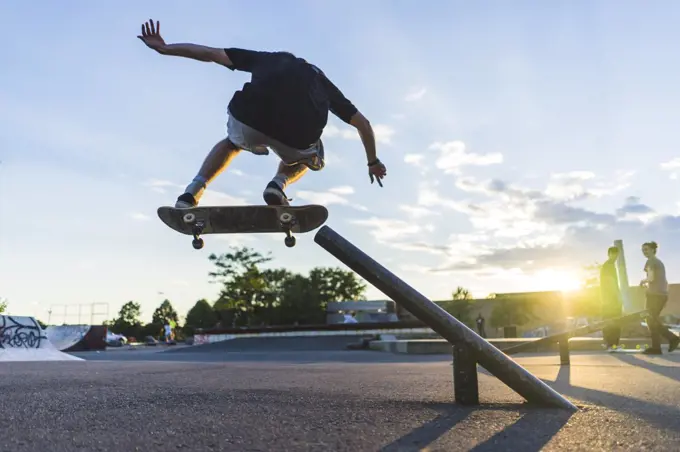 Athletic teenage skateboarder doing a grind