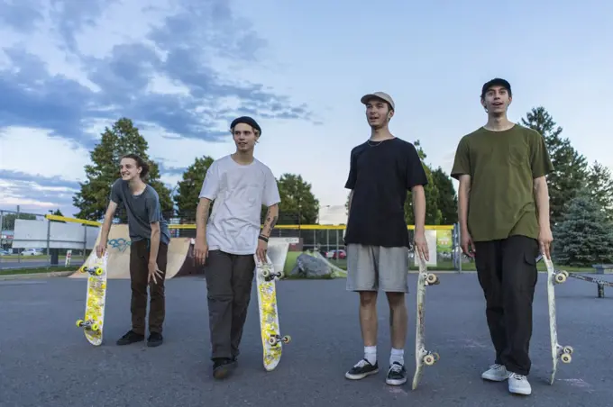 Group of athletic teenage skateboarders in skatepark