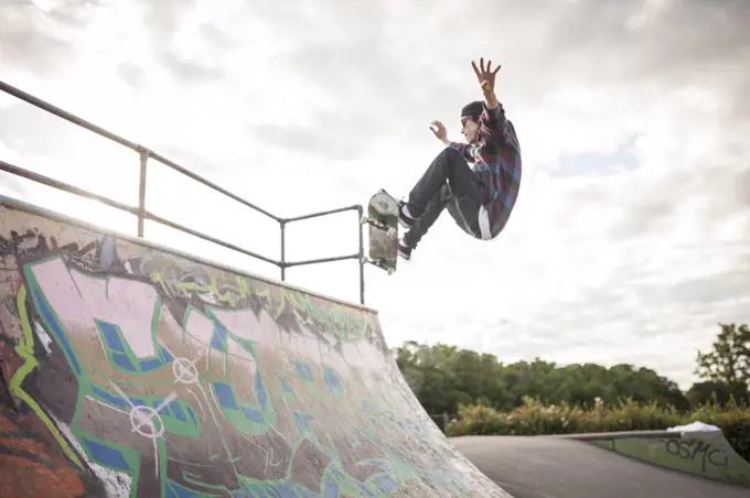 Skateboarder skateboarding in skatepark on ramp